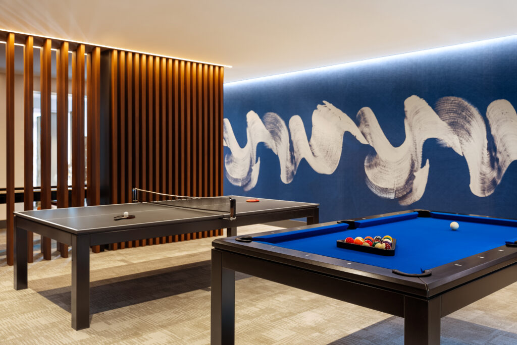 A pool table next to a ping pong table in a game room