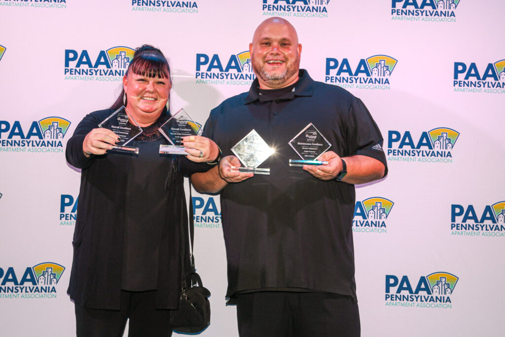 Two Scully Company employees smiling and holding out their awards