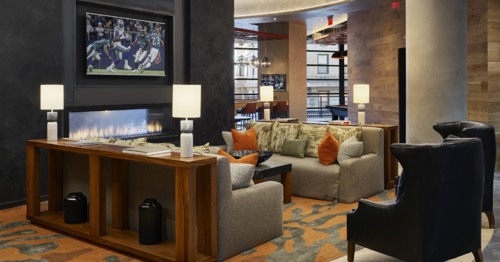 Lounge with comfortable couches and a football game on the television above a fireplace