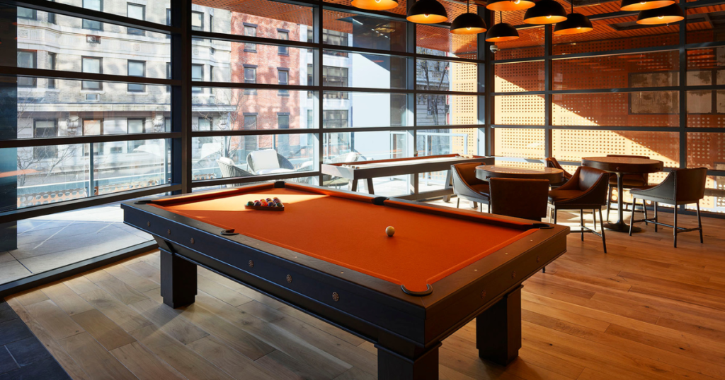 An orange pool table with a view of the local Philadelphia neighborhood