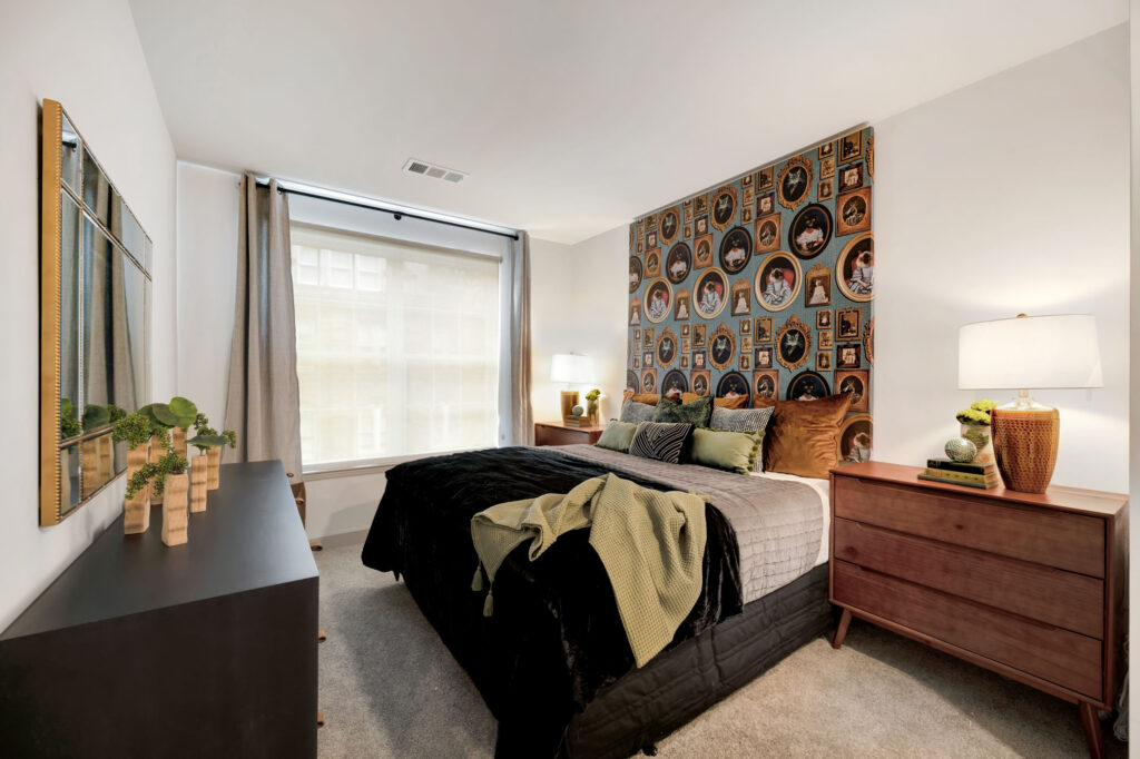 Beautiful bedroom at The Whit apartments with a colorful accent wall